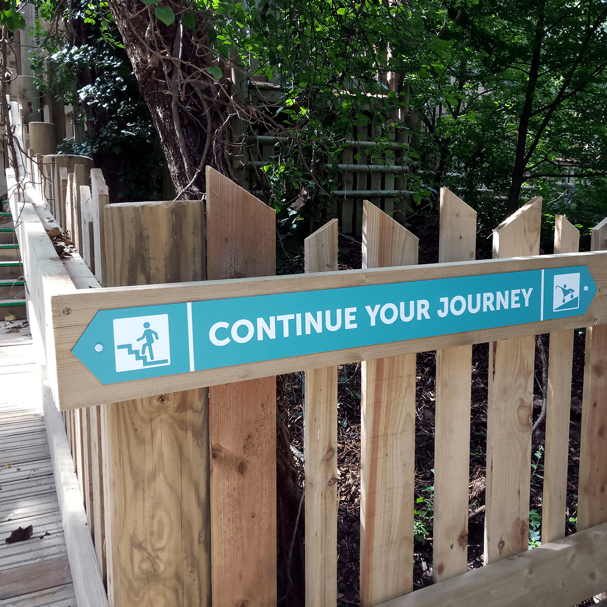 Wayfinding pointer that reads Continue your journey with an arrow pointing left to stairs and right to an accessible ramp